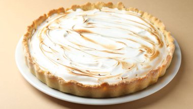 Açık kahverengi masada nefis kremalı pasta, yakın plan.