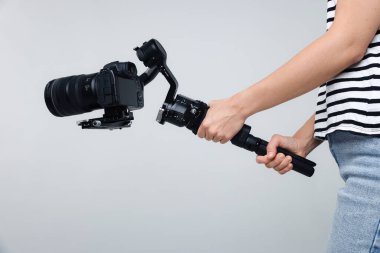 Işık arkaplanında kamera olan titreşim dengeleyici kullanan kameraman, yakın plan