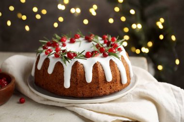 Bulanık ışıklara karşı kremalı, kızılcıklı ve biberiyeli lezzetli bir Noel pastası.