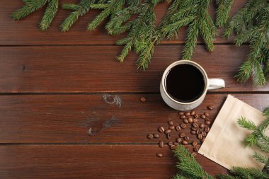 Aromatik kahve fincanda, fasulye ve köknar ağacı dalları ahşap masada, düz yerde. Metin için boşluk