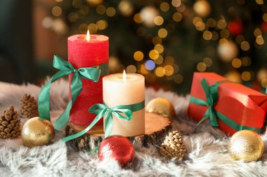 Bulanık ışıklara karşı sahte kürkte mum yakmak ve Noel süsü vermek. Bokeh etkisi