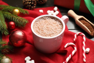 Bardakta sıcak kakao, marşmelov ve ahşap masada Noel süsü, yakın plan.