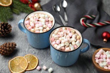 Gri masada marşmelovlu lezzetli kakao ve Noel dekoru, yakın plan.