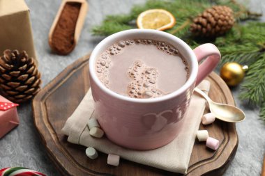 Lezzetli kakao, marşmelov ve Noel dekoru gri masada, yakın plan.