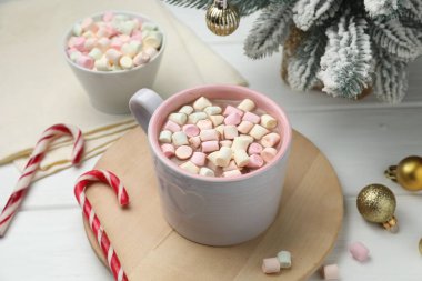 Marşmelovlu lezzetli kakao ve beyaz ahşap masada Noel dekoru, yakın plan.