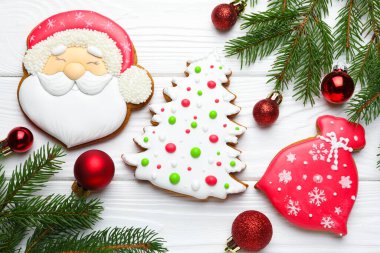 Lezzetli zencefilli kurabiyeler ve beyaz ahşap masa üzerindeki şenlikli dekorasyon.