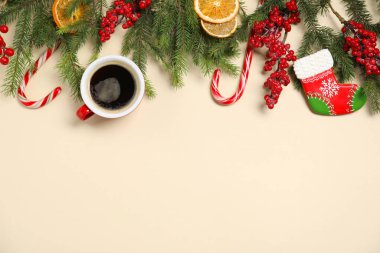 Düz kompozisyon, aromatik kahve fincanı, köknar ağacı dalları ve bej arka planda Noel dekoru. Metin için boşluk