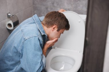 Genç adam tuvaletteki klozet yüzünden midesi bulanıyor.