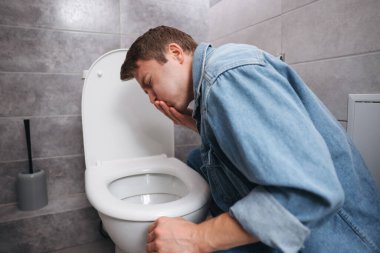 Genç adam tuvaletteki klozet yüzünden midesi bulanıyor.