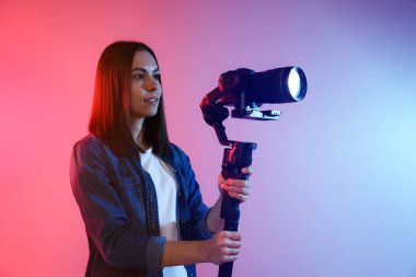 Arkaplanda renk ışıklarıyla titreşim dengeleyici kullanarak kamerada çekim yapan kameraman