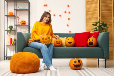 Mutlu Cadılar Bayramı. Evde balkabağı olan bir kadın var.