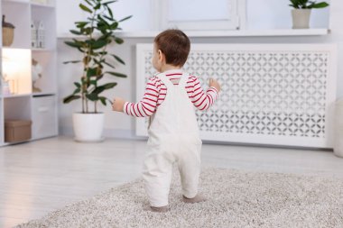 İlk adımlar. Sevimli küçük bebek. Evinde yerde yürüyor.