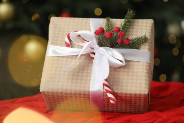 Noel hediyesi olarak ekoseli şeker ve bulanık ışıklara karşı yakın çekim.