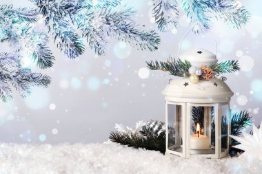 Mutlu Noeller ve Mutlu Noeller kartı. İçinde mum bulunan dekoratif fener ve arka planda köknar dalları, bokeh ışıkları