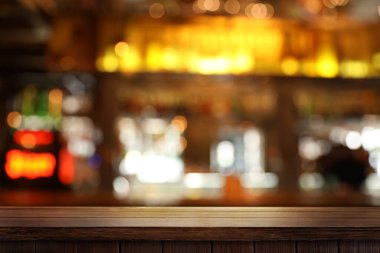 Bardaki boş ahşap masa, bulanık arka plan. Tasarım için boşluk