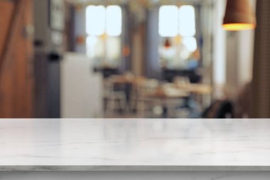 Kafeteryada boş beyaz mermer masa, bulanık arkaplan. Tasarım için boşluk