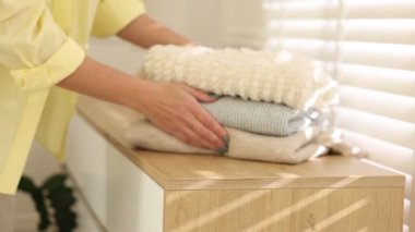 Kadın giysileri kapalı dolaba koyuyor, yakın plan.