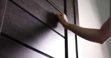 Apartman kapısını çalan adam, alçak açılı.