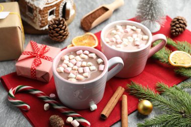 Gri masada marşmelovlu, tarçınlı ve Noel dekorlu lezzetli kakao, yakın plan.