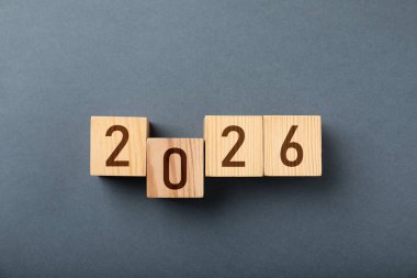 Yeni 2026 yılı. Gri arkaplanda numaraları olan küpler, üst görünüm