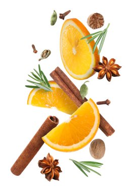 Beyaz arka plana düşen sıcak şarap için portakal dilimleri ve baharatlar. Geleneksel Noel içkisi