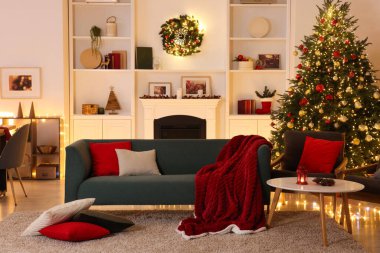 Noel ağacı, kanepe, şömine ve şenlikli dekorlu şık bir oda. İç tasarım