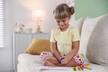 Evdeki koltukta keçeli kalemle çizen sevimli küçük kız, mesaj atmak için yer var.