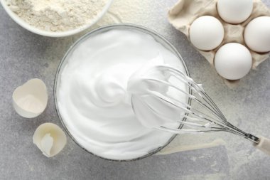 Beyazları kaseyle, yumurtalarla, yumurta kabuklarıyla, unla çırpıp, gri desenli masada, düz bir şekilde yatıyordu.