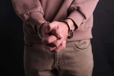 Siyah arka planda kelepçeli adam, yakın plan.