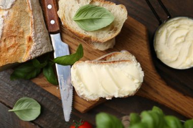 Tahta masaya tereyağlı, fesleğenli ve bıçaklı baget dilimleri.