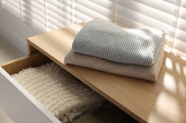 İçerideki pencerenin yanındaki dolapta temiz giysiler var, yakın plan.