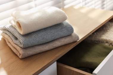 İçerideki pencerenin yanındaki dolapta temiz giysiler var, yakın plan.