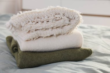 İçerideki yatağın üzerine temiz giysiler yığılır, yakın plan.