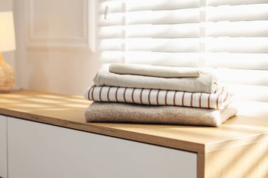 İçerideki pencerenin yanındaki dolapta temiz giysiler var, yakın plan.