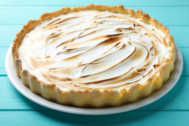 Turkuaz ahşap masada lezzetli limonlu turta, yakın plan.