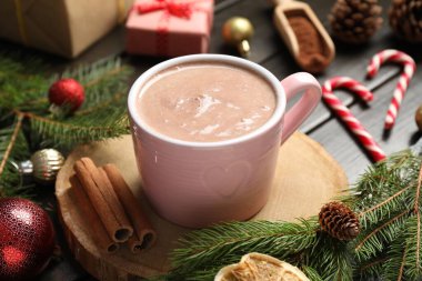 Lezzetli sıcak kakao bardakta ve Noel dekoru ahşap masada, yakın plan