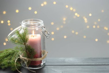 Gri ahşap masada bulanık ışıklara karşı güzel bir Noel feneri ve şenlikli bir dekor. Bokeh etkisi