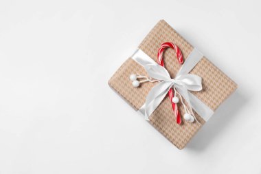 Beyaz arka planda baston şekerle süslenmiş Noel hediyesi, üst manzara. Metin için boşluk