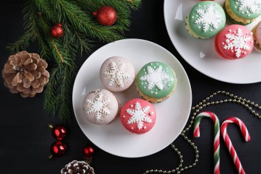 Lezzetli badem kurabiyeleri ve Noel süsleri siyah masada, düz yerde.