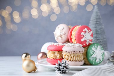 Beyaz masada, bulanık ışıklara karşı lezzetli kurabiyeler ve Noel süsü, yakın plan. Metin için boşluk