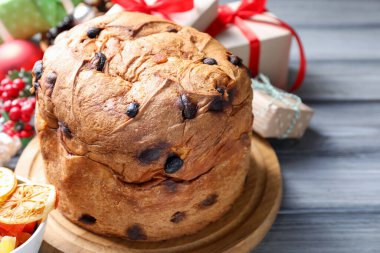 Lezzetli Noel pastası ve gri ahşap masadaki hediye kutuları..
