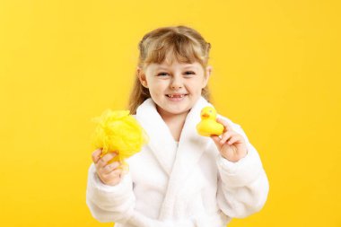 Bornozlu mutlu kız lif ve sarı arka planda plastik ördek