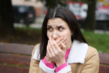 Gastrobağırsak sorunu. Açık havada mide bulantısı çeken genç bir kadın.