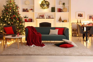 Noel ağacı, kanepe, şömine ve şenlikli dekorlu şık bir oda. İç tasarım