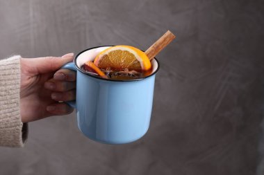 Gri arka planda lezzetli şaraplı bir kadın, yakın plan. Metin için boşluk