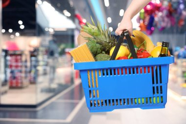 Süpermarkette farklı gıda ürünlerinin olduğu alışveriş sepeti, yakın çekim.