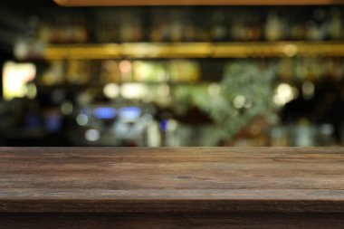 Bardaki boş ahşap masa, bulanık arka plan. Tasarım için boşluk