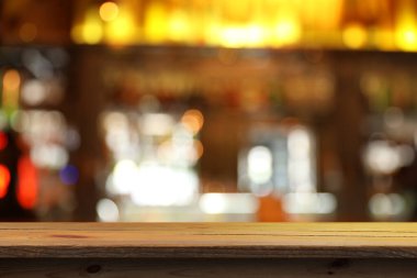 Bardaki boş ahşap masa, bulanık arka plan. Tasarım için boşluk