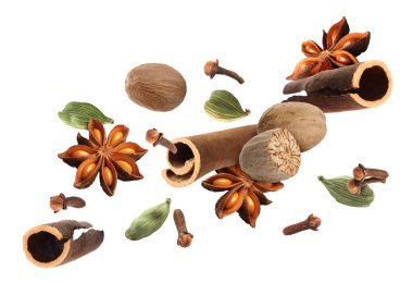 Noel içecekleri ve yemekler için farklı baharatlar. Beyaz arka plana dökülen anason, kakule, tarçın, hindistan cevizi ve karanfil.