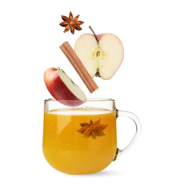 Soğuk mevsim için sağlık takviyesi. Elma parçaları, tarçın ve anason beyaz arka planda fincana dökülüyor